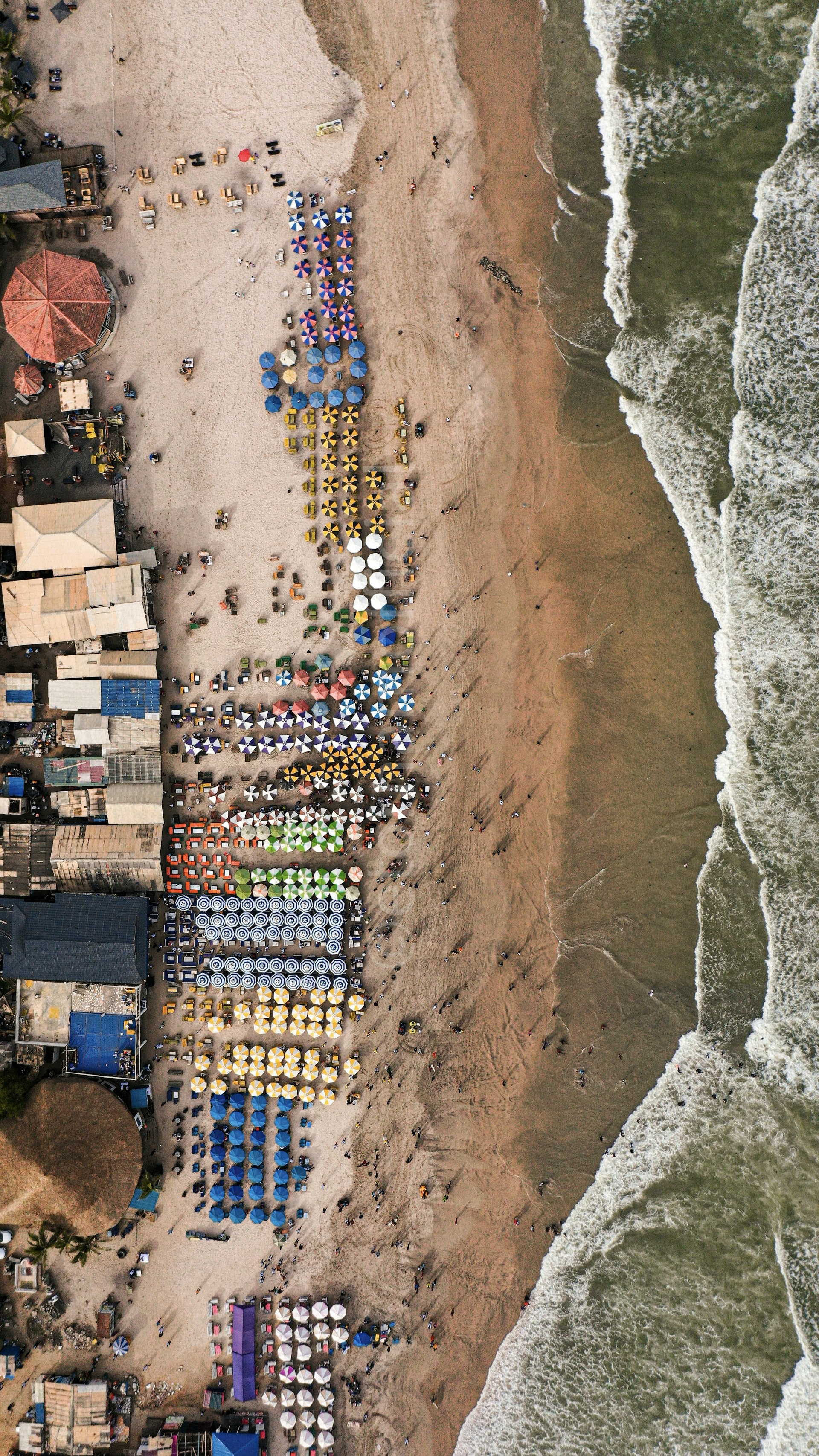 Aerial view of Labadi Beach in Accra packed with rows of colourful umbrellas