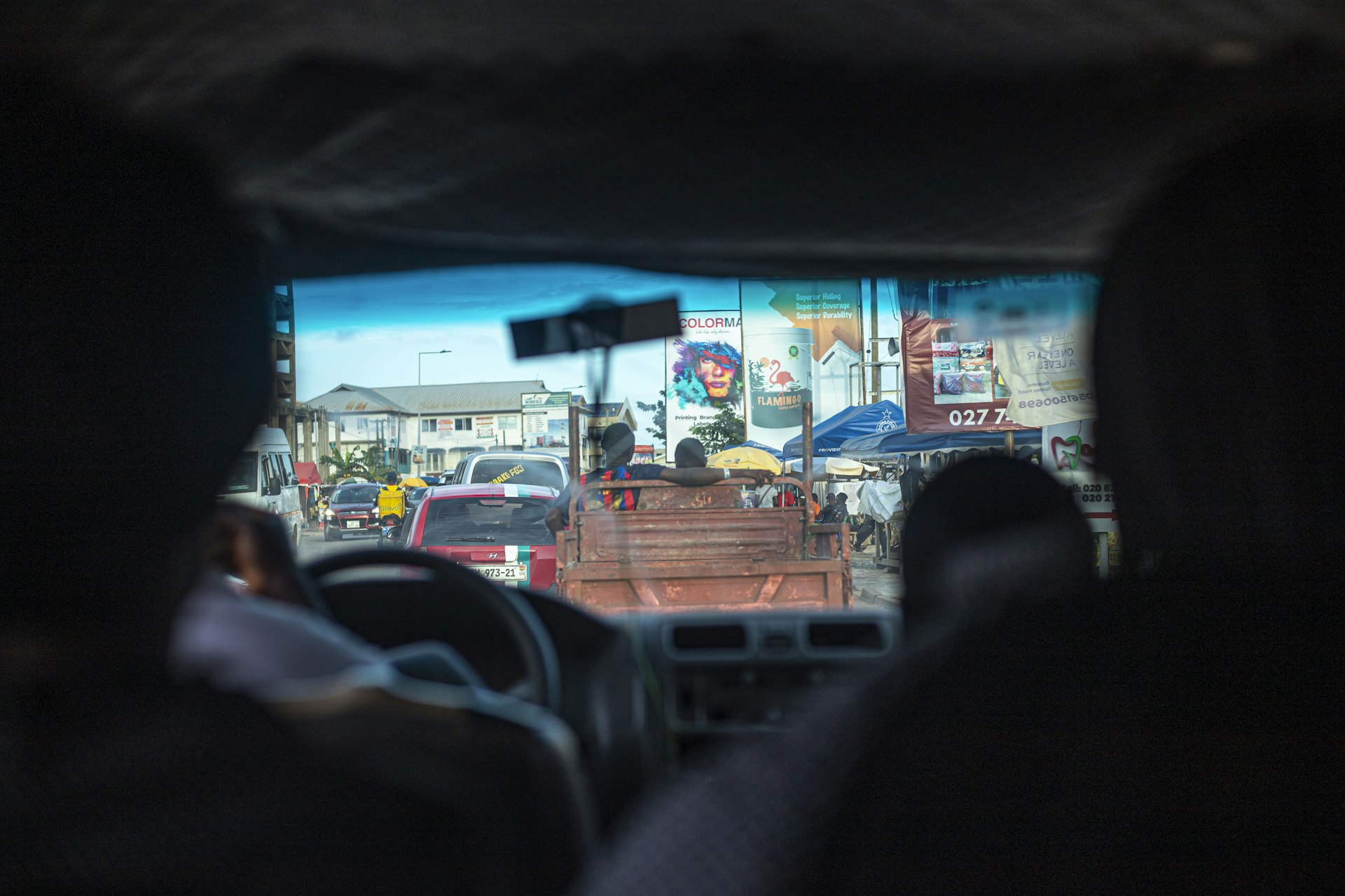 An Accra street seen through the windscreen of a moving vehicle in Ghana