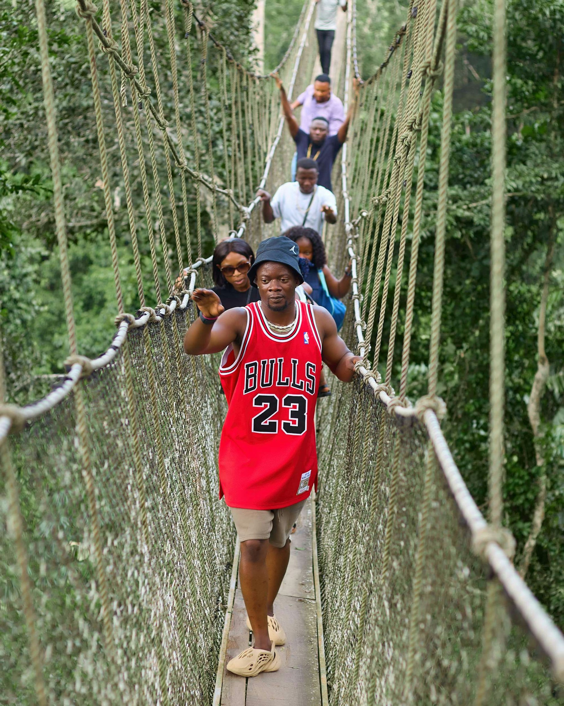 Visitors crossing the rope canopy walkway at Kakum National Park