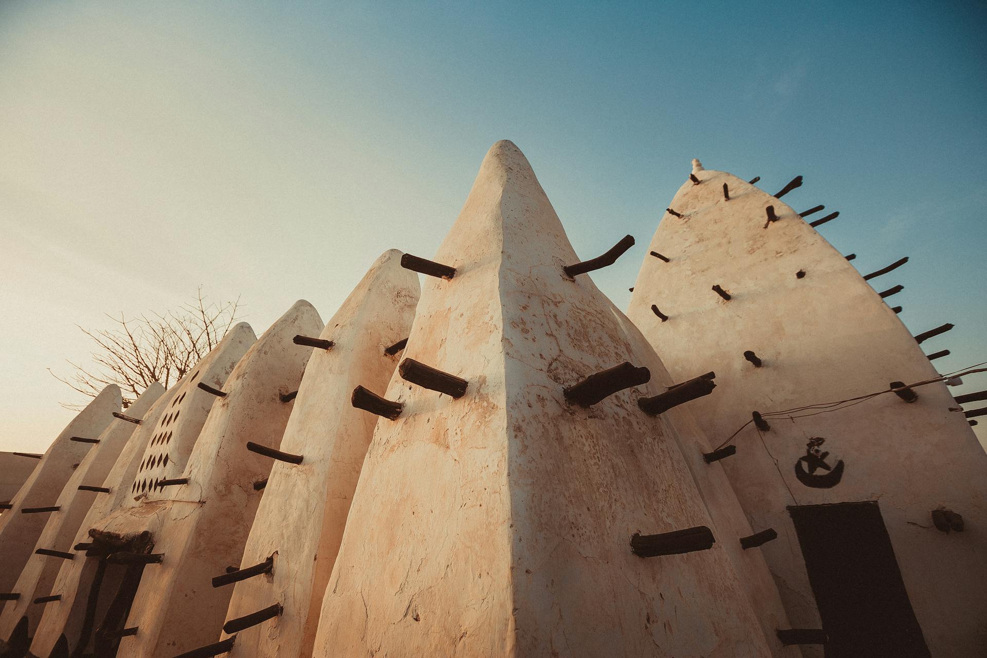 The mud-and-timber spires of the ancient Larabanga Mosque at sunset, Northern Ghana